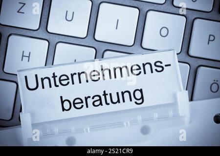 The folder of a hanging file in front of a computer keyboard on the subject of management consultancy Austria Stock Photo