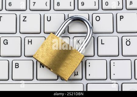 A padlock on a computer keyboard. Symbol photo for data security and hacking Stock Photo