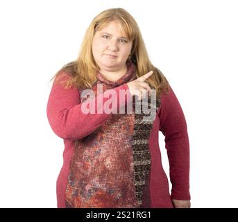 A woman with long blonde hair poses in a studio, confidently pointing to the side. Stock Photo