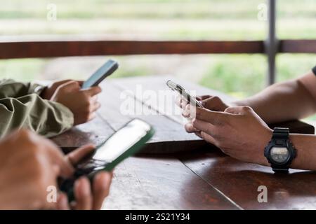 Three young people using mobile phones outdoors. Using social media and digital online living on vacation and playing social media. online marketing, Stock Photo