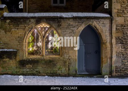 Arched door and window at night in the winter snow. Stow on the Wold, Cotswolds, Gloucestershire, England Stock Photo