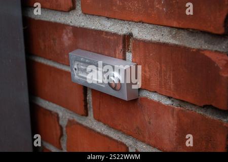 Close up of a simple house doorbell on a bricks wall near the front door Stock Photo