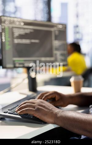 Programmer typing on keyboard, developing machine learning APIs solving complex problems. Close up of man writing code, training predictive models capable of handling complex tasks Stock Photo