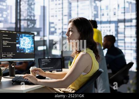 Data scientist utilizing cloud computing resources and platforms to train and deploy large scale machine learning models. Woman in business office monitoring and maintaining company systems Stock Photo