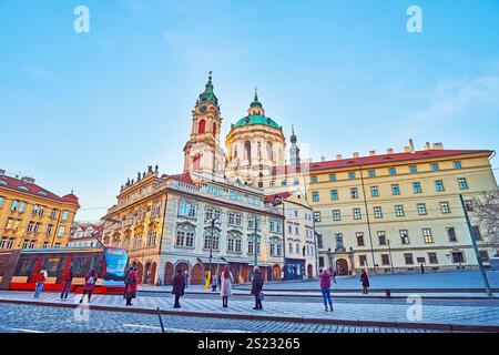 Malostranske Square with historic townhouses, St Nicholas Church and a modern tram on the stop, Prague, Lesser Quarter, Czechia Stock Photo