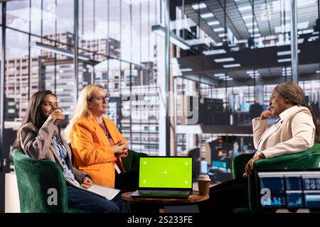 Group of multiethnic women working hard to prove themselves next to chroma key, fighting for success in a men dominated business industry. Diverse colleagues ensuring firm expansion. Stock Photo
