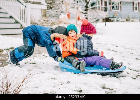 Children enjoying a joyful sled ride together on a snowy winter day Stock Photo