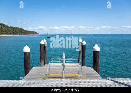 View from jetty, Kingfisher Bay K'gari Fraser Island, blue tropical ocean water and boats Stock Photo