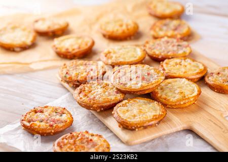 Small tarte flambees or pizzas with cheese, onion and bacon made of pretzel dough Stock Photo