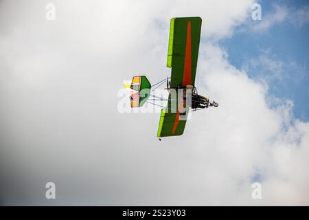 Aerobatic airplane leaves smoke trail in stunning performance against blue sky. Skilled pilot Stock Photo