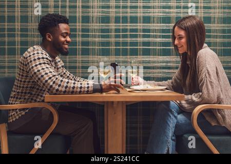 Two friends are having dinner at restaurant. They are sitting, talking and enjoying time together. Stock Photo