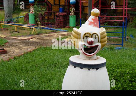 Ceramic clown used as a trash can with a castle in the background Stock Photo