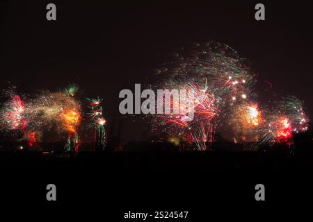 Fireworks over a city on a windy night Stock Photo