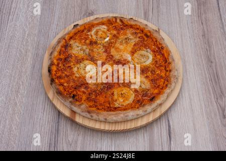 Italian culinary Still Life. A four cheese pizza seen from above and placed on a wooden tray Stock Photo