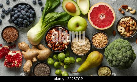 various fresh healthy products on grey table, top view. Healthy food clean eating selection: fruit, vegetable, seeds, superfood, cereals, leaf vegetab Stock Photo