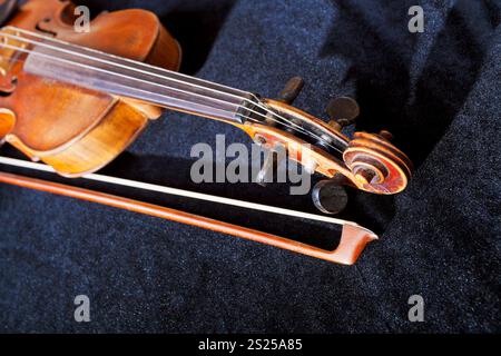 violin pegbox and bow on black velvet background close up Stock Photo