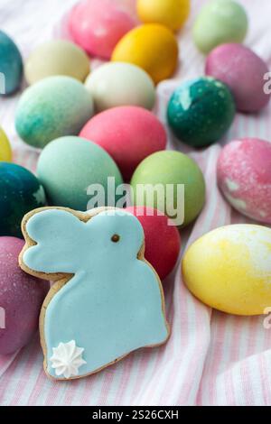 Multi-colored Easter eggs with decorative bunnies on a pink tablecloth, Happy Easter holiday Stock Photo