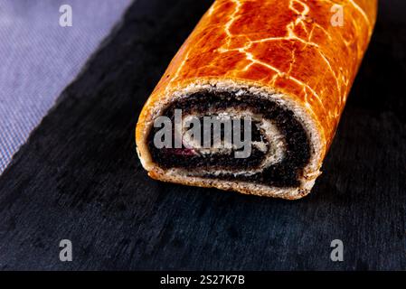 Traditional Hungarian Christmas cookies with poppy seed on a black cutting board. Stock Photo