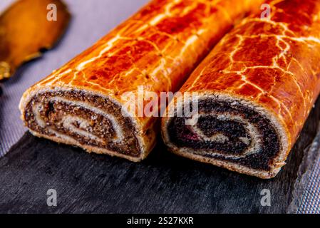 Traditional Hungarian Christmas cookies with poppy seed and walnut on a black cutting board. Stock Photo