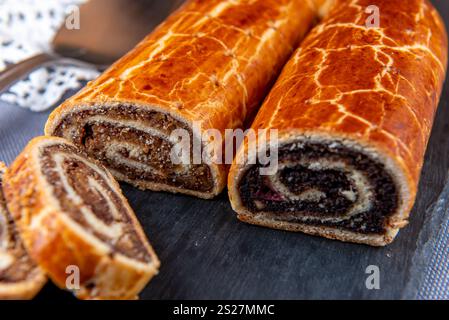 Traditional Hungarian Christmas cookies with poppy seed and walnut on a black cutting board. Stock Photo
