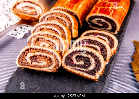 Traditional Hungarian Christmas cookies with poppy seed and walnut on a black cutting board. Stock Photo
