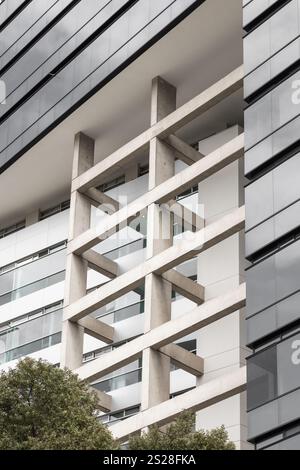 A large white building with a sleek, modern design. Its clean lines and minimalist structure create an elegant and sophisticated architectural style, Stock Photo