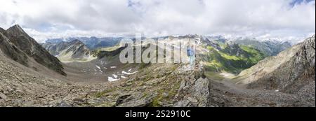 Panorama mountaineer on a steep rocky ridge, at the summit of Lasoerling, view of mountains of the Venediger Group, Lasoerling Group, Hohe Tauern Nati Stock Photo