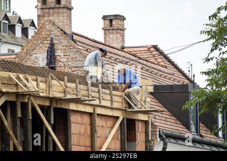 Two construction workers working on a house roof. Roofer at work Austria Stock Photo