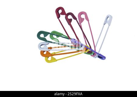 Many colourful safety pins lie on a white background Austria Stock Photo