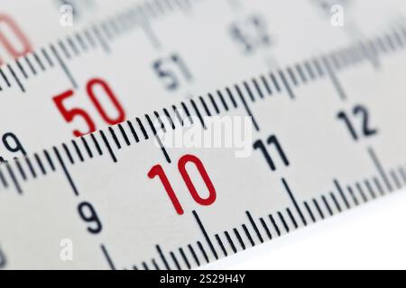 A carpenter's white folding rule lies in front of a white background. Austria Stock Photo
