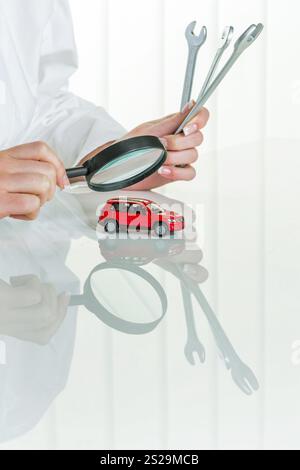 A model of a car is examined by a doctor. Symbol photo for workshop, service and car purchase. Austria Stock Photo