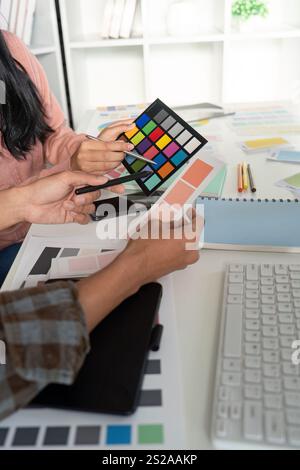 Creative design team collaborates on graphic color selection in modern office space Stock Photo