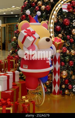 Christmas decoration bear on unicycle holding boxes of gift Stock Photo