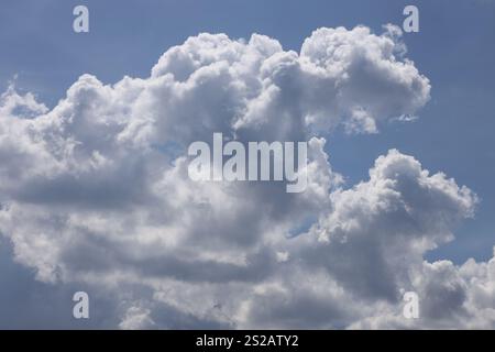 fluffy white gray clouds against deep blue sky Stock Photo