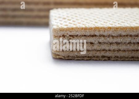 Two crispy waffles with filling placed on a clean white background, showcasing their golden texture and sweet layers Stock Photo