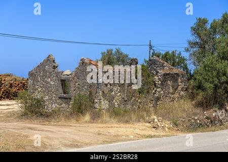 Old ruin without a roof and overgrown with plants along the road in Portugal Stock Photo