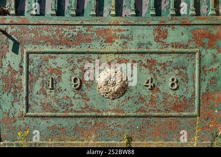 The year 1948 numbers in 3D metal on a green rusty fence in a village in Portugal Stock Photo