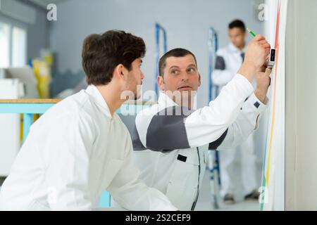 painter with apprentice and client Stock Photo