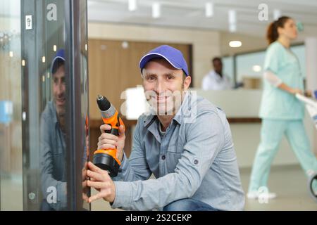 bearded man using hammer drill in a hospital Stock Photo
