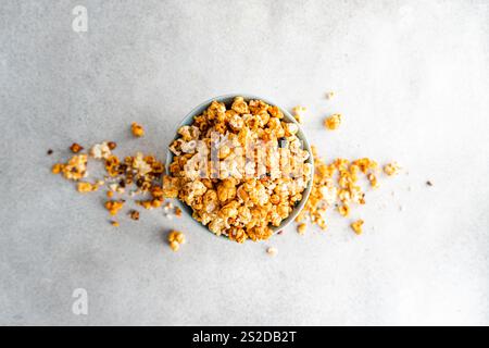 Overhead view of an overflowing bowl of Sweet caramel popcorn on a table Stock Photo