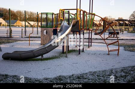 Slide and climbing frame at a snow-covered playground in a residential ...