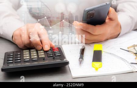 Calculating expenses and analyzing financial data in a professional workspace with notes and stationery nearby for reference. Stock Photo
