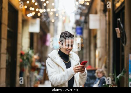 Young man using smartphone in city center during christmas time Stock Photo