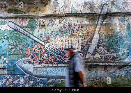 Pontevedra, Spain - 21, 2024: Abstract painting on wall in a street with man walking by Stock Photo