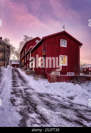 Red old wooden houses in the evening with light in the window Stock Photo