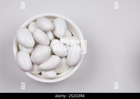 Bright, white caramel coated almonds, in suitable packaging, on a white background. Stock Photo