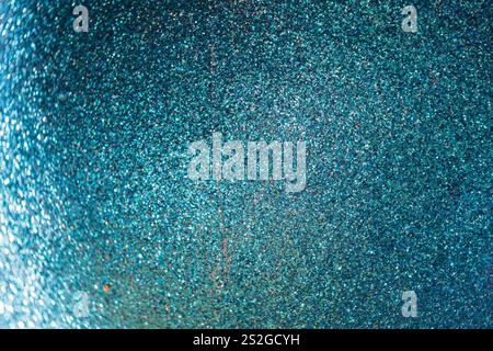 A close-up view of a shimmering blue surface, densely packed with fine glitter particles, reflecting light. Festive background. Stock Photo