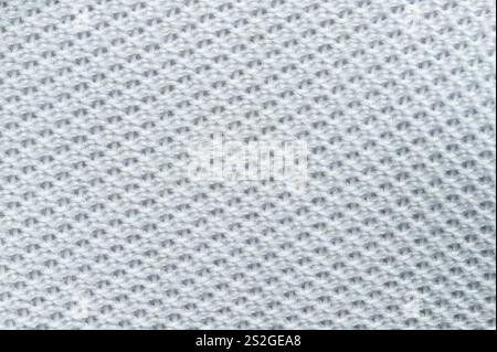 Close-up showcases soft light gray knitted fabric, emphasizing  weave and texture in intricate detail. Stock Photo