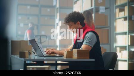 Parcel processing specialist scans packages using barcode scanner, works on laptop. Warehouse employees checking carboard boxes for shipping to customers. E-commerce store or postal service storage. Stock Photo