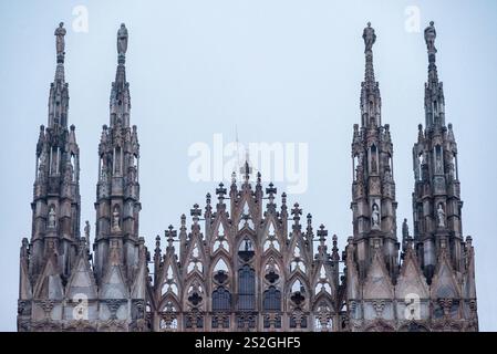 Details and particulars of the Statues on the spires of the facade of the Duomo of Milan. Statuette of the Madonna in the fog Stock Photo